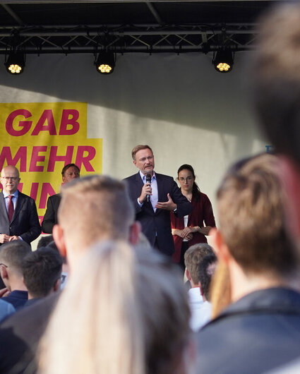 Christian Lindner, Michael Theurer, Hans-Ulrich Rülke und andere stehen während einer Wahlkampfveranstaltung auf der Bühne. Im Vordergrund sind zahlreiche Zuhörer zu sehen.